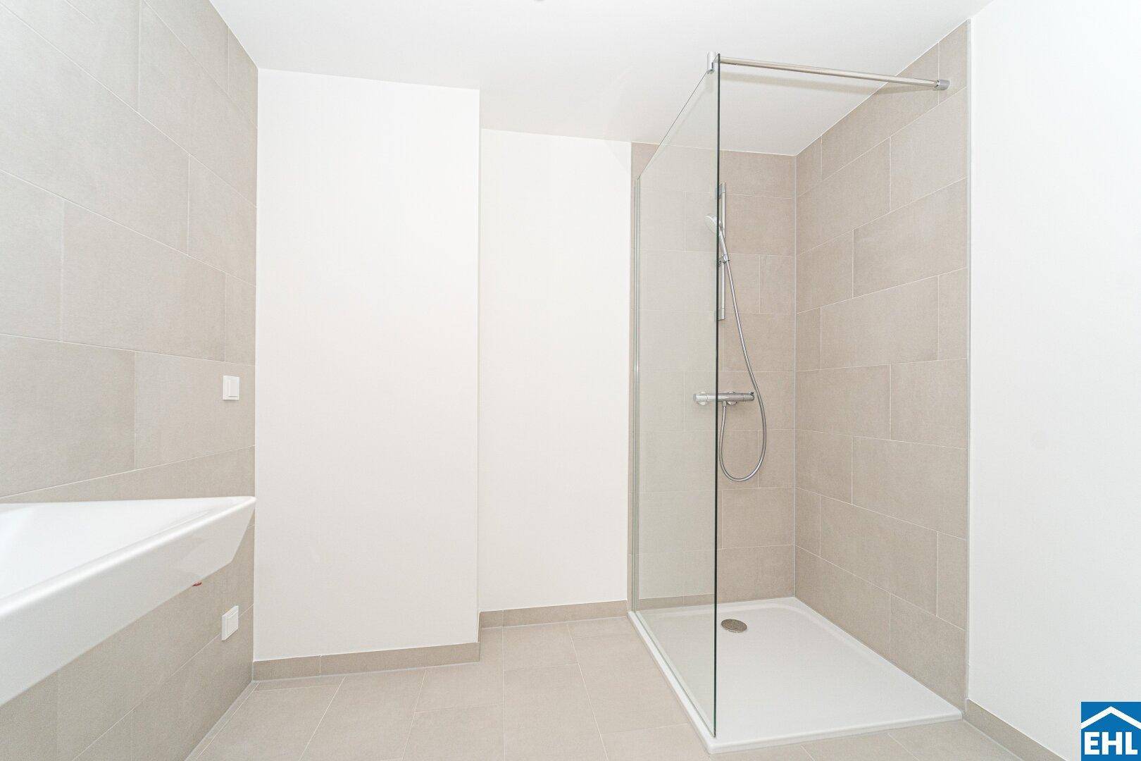 Modernes Badezimmer mit hellgrauen Fliesen, ebenerdiger Dusche und minimalistischem Waschbecken.