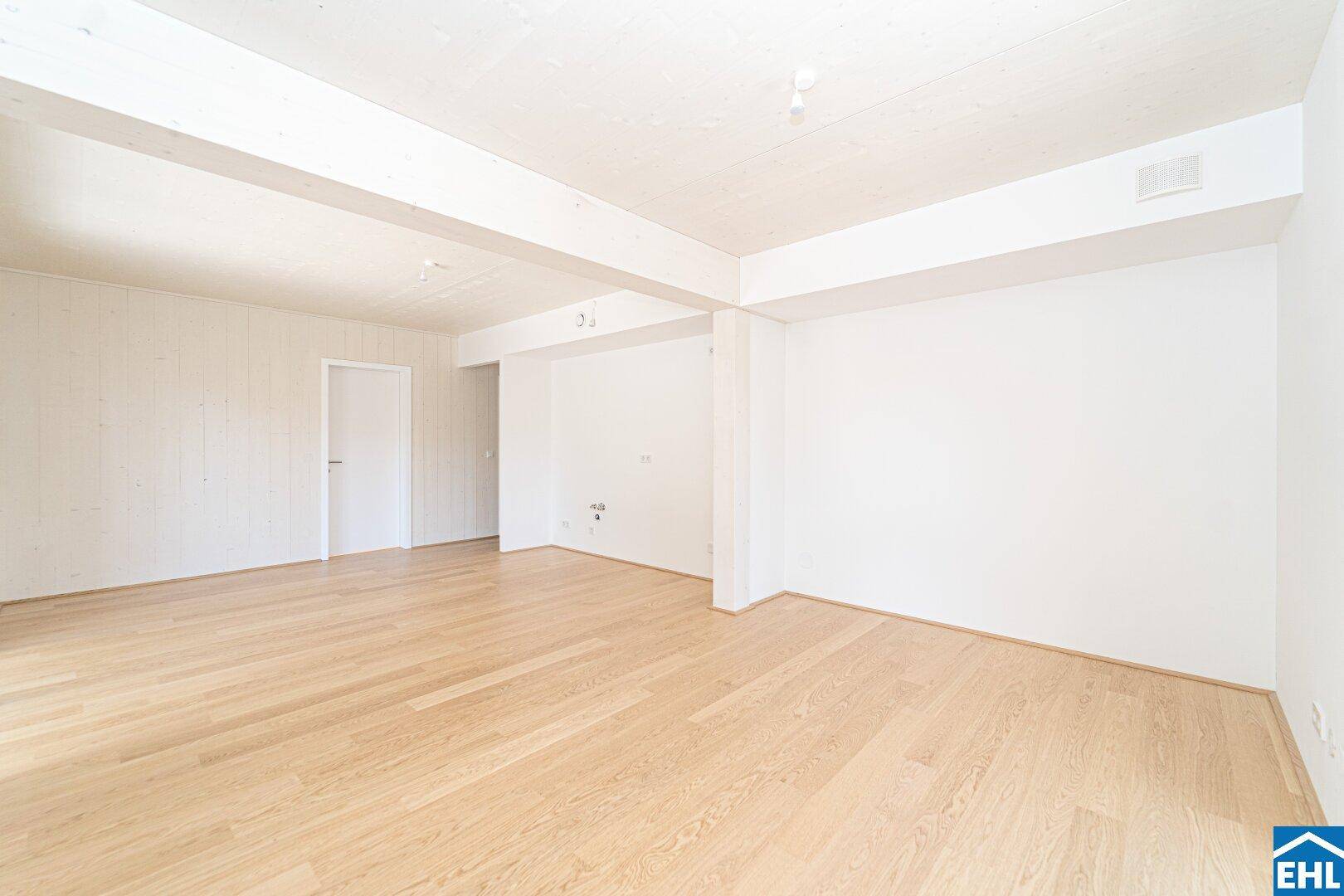 Großer, heller Raum mit Holzboden und sichtbaren Deckenbalken, vielseitig nutzbar.
