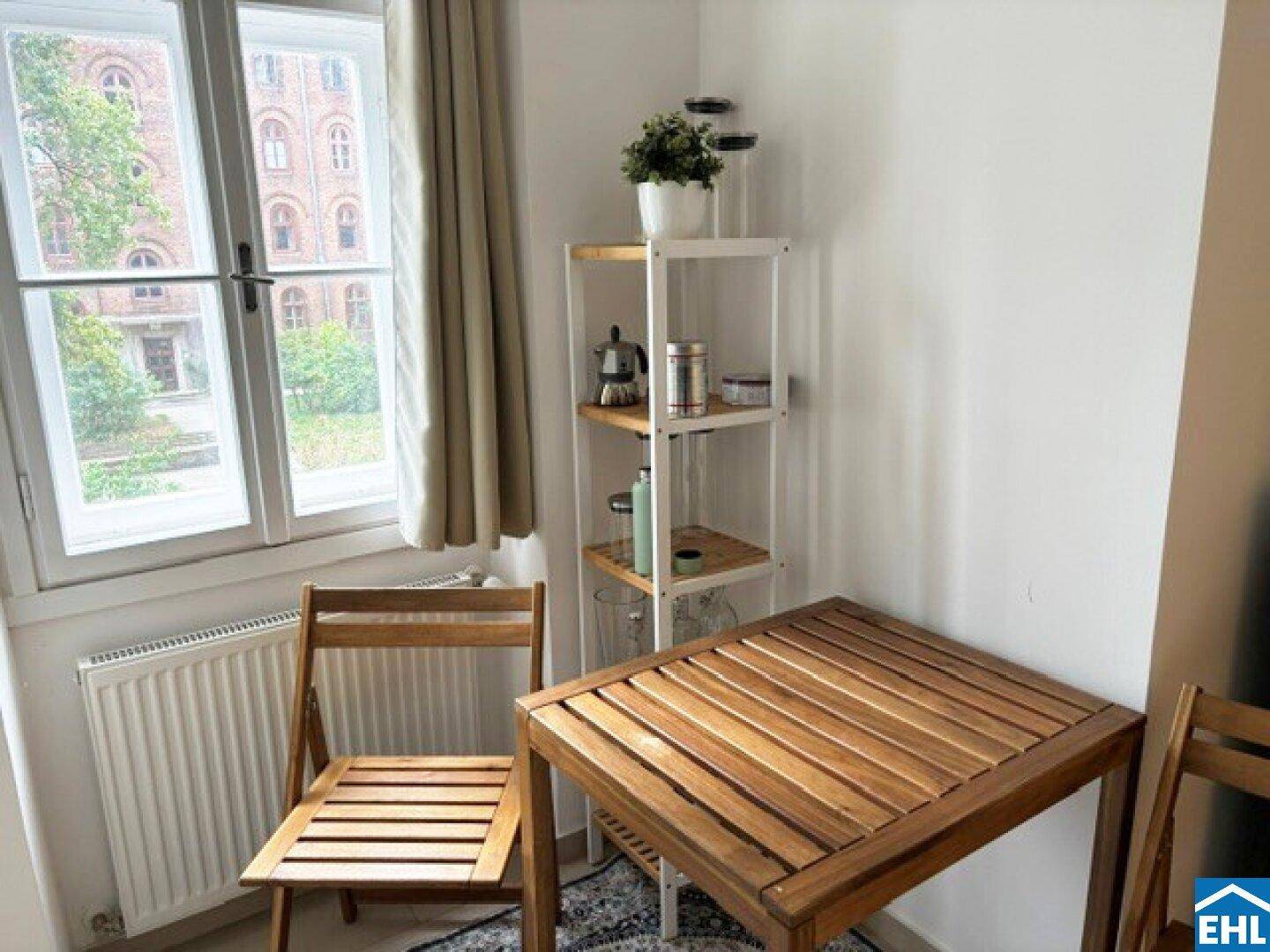 Kleiner Essbereich in der Küche mit Holztisch und Stühlen, ideal für Frühstück am Fenster.