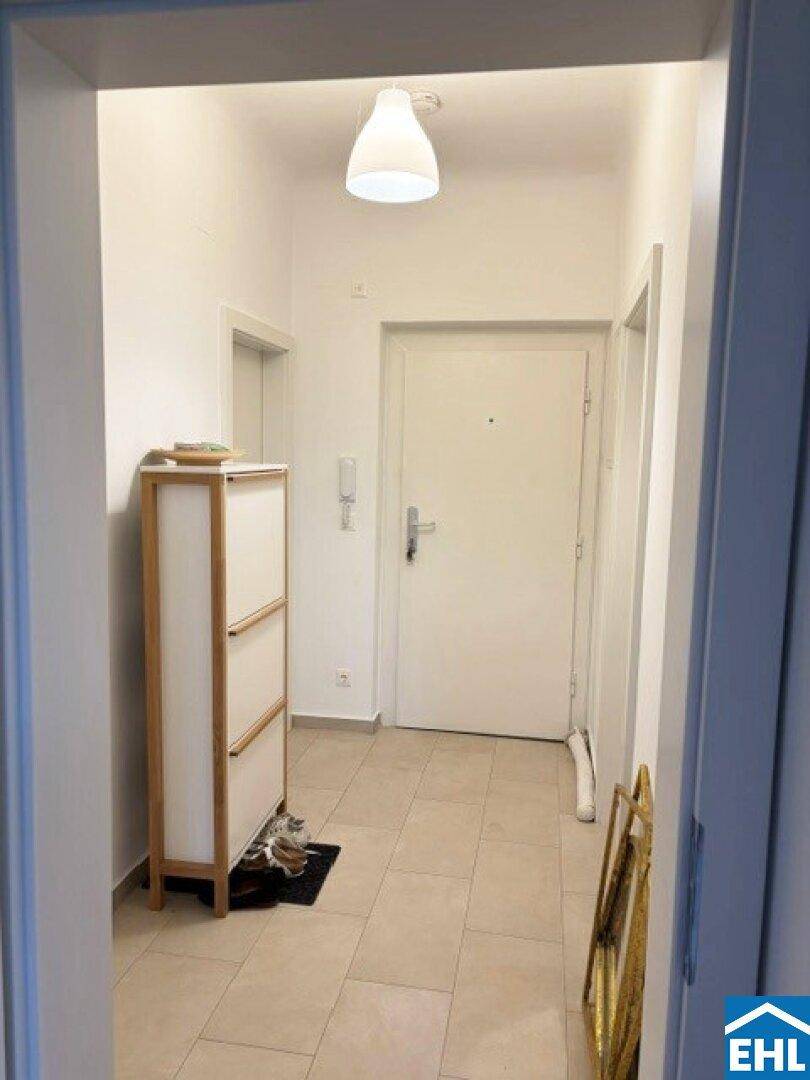 Heller Flur mit Fliesenboden und Schuhschrank, führt zu den weiteren Räumen der Wohnung.