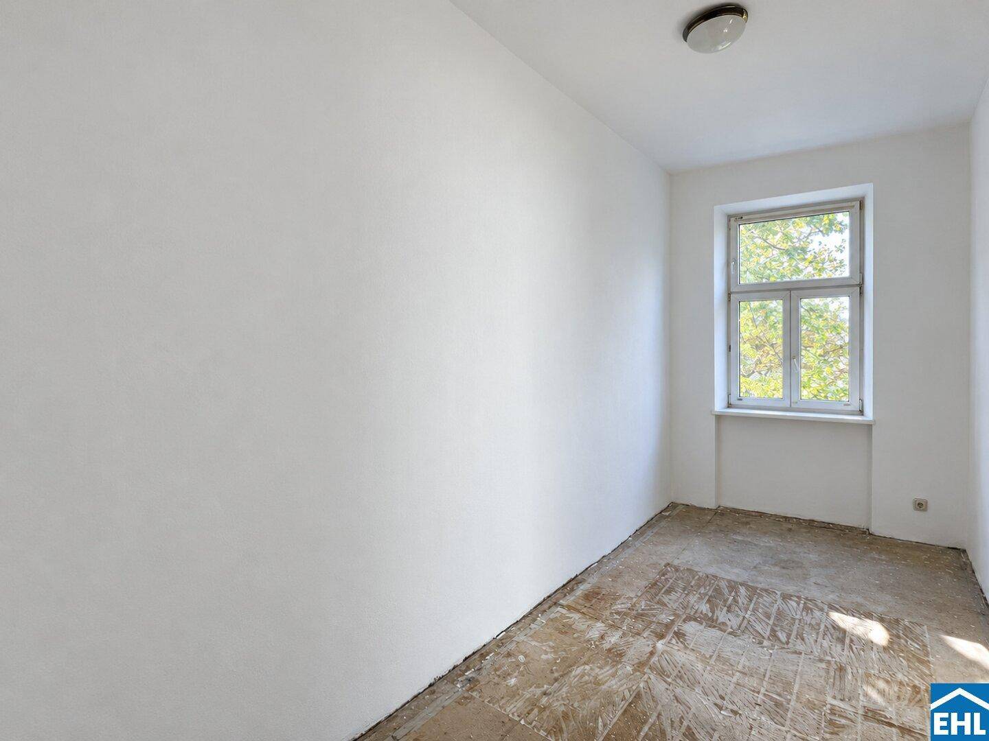 Kleiner, heller Raum mit einem Fenster und vorbereitetem Boden für die weitere Gestaltung.