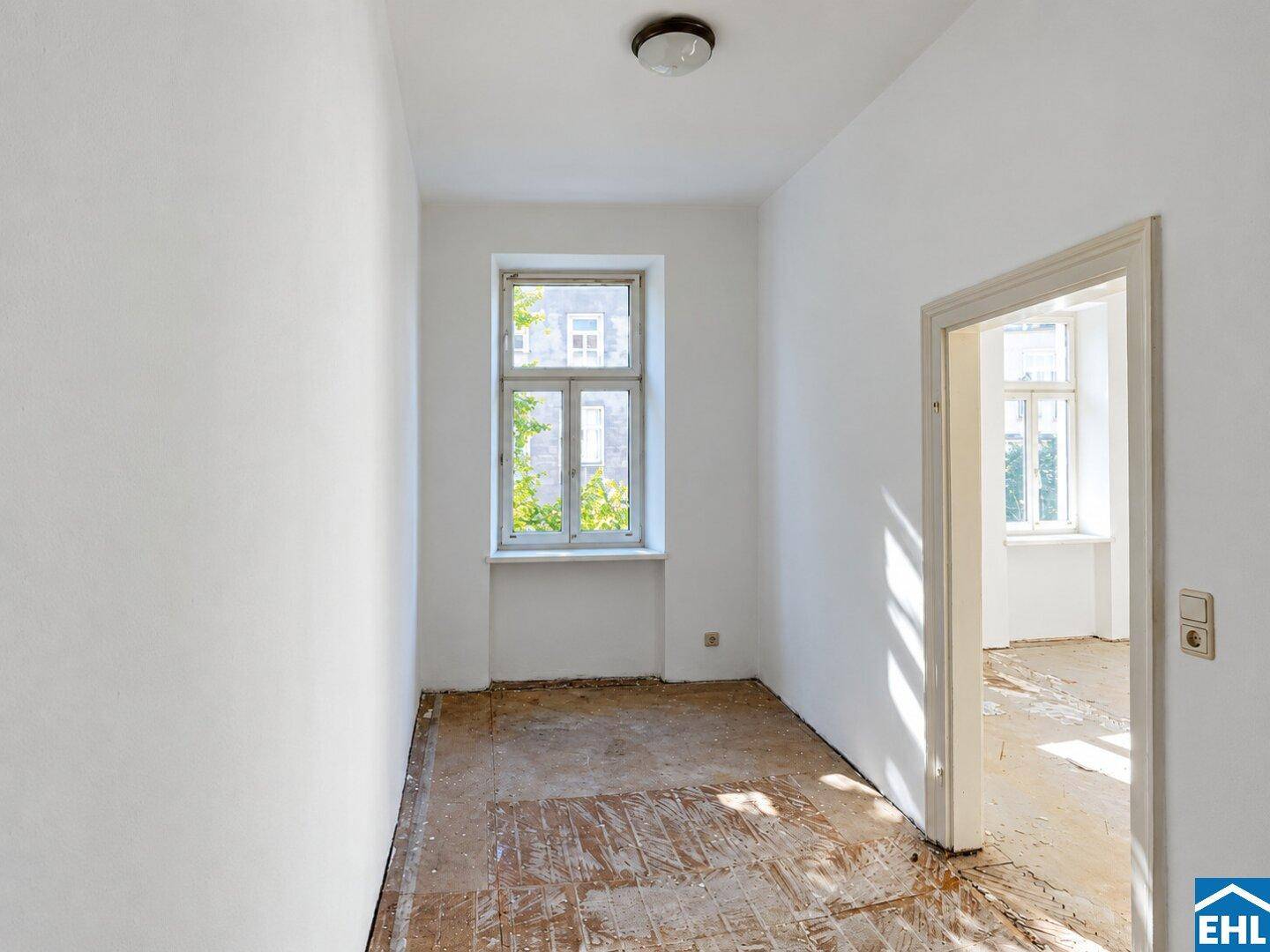 Heller Raum mit einem Fenster und Blick ins Grüne, bereit für eine individuelle Renovierung.