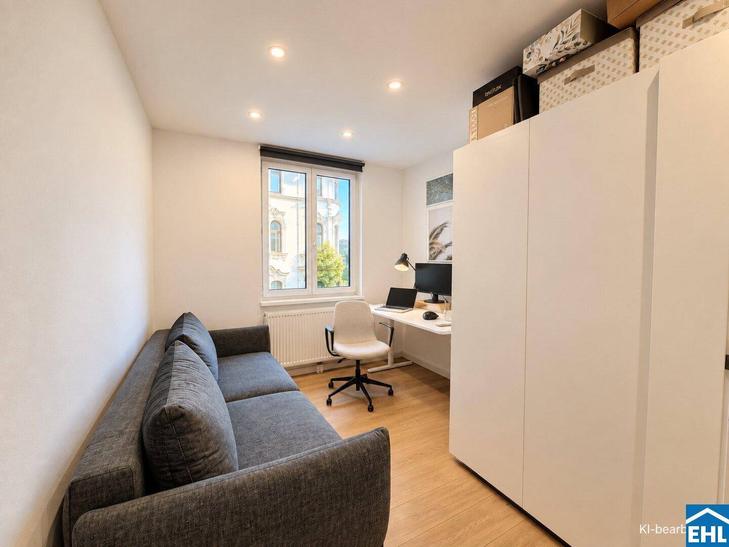 Funktionales Arbeitszimmer mit Schreibtisch, Sofa und Blick auf die umliegenden Gebäude.