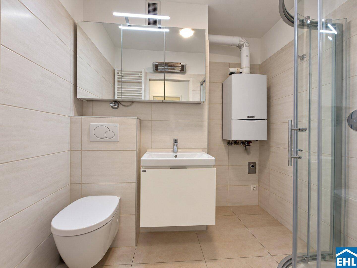 Modernes Badezimmer mit Dusche, Hänge-WC und Waschbecken, hell gefliest und funktional.