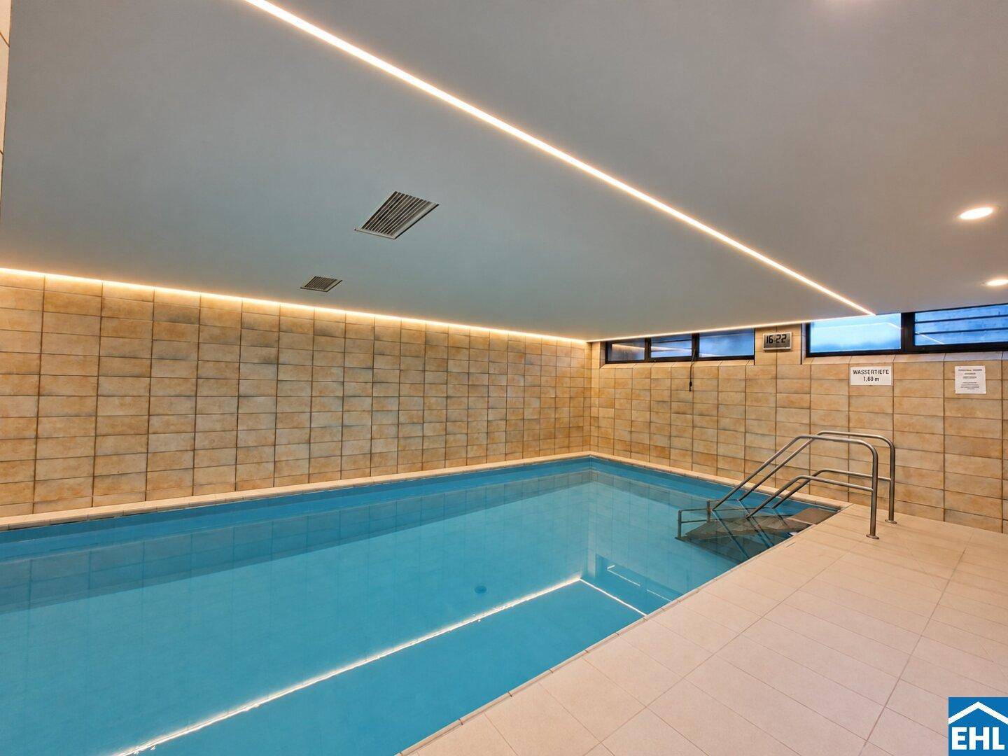 Großzügiges Hallenbad mit klarem Wasser und moderner Beleuchtung, bietet Erholung und Sport.