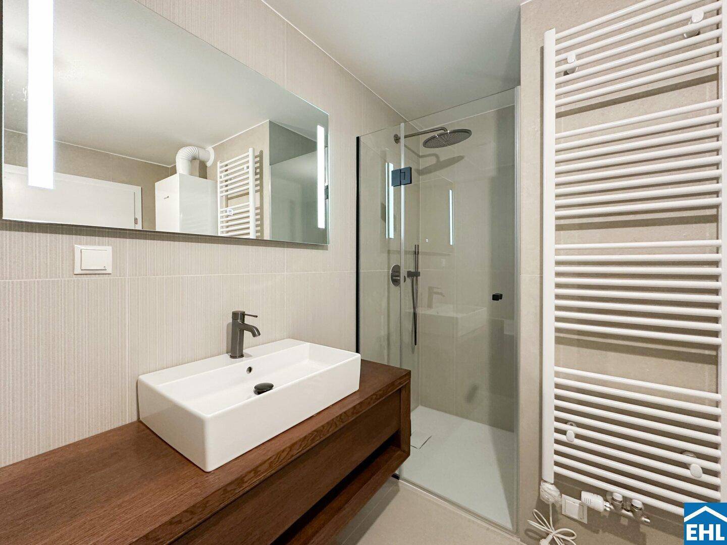 Modernes Badezimmer mit begehbarer Dusche, Einzelwaschbecken und beheiztem Handtuchhalter.