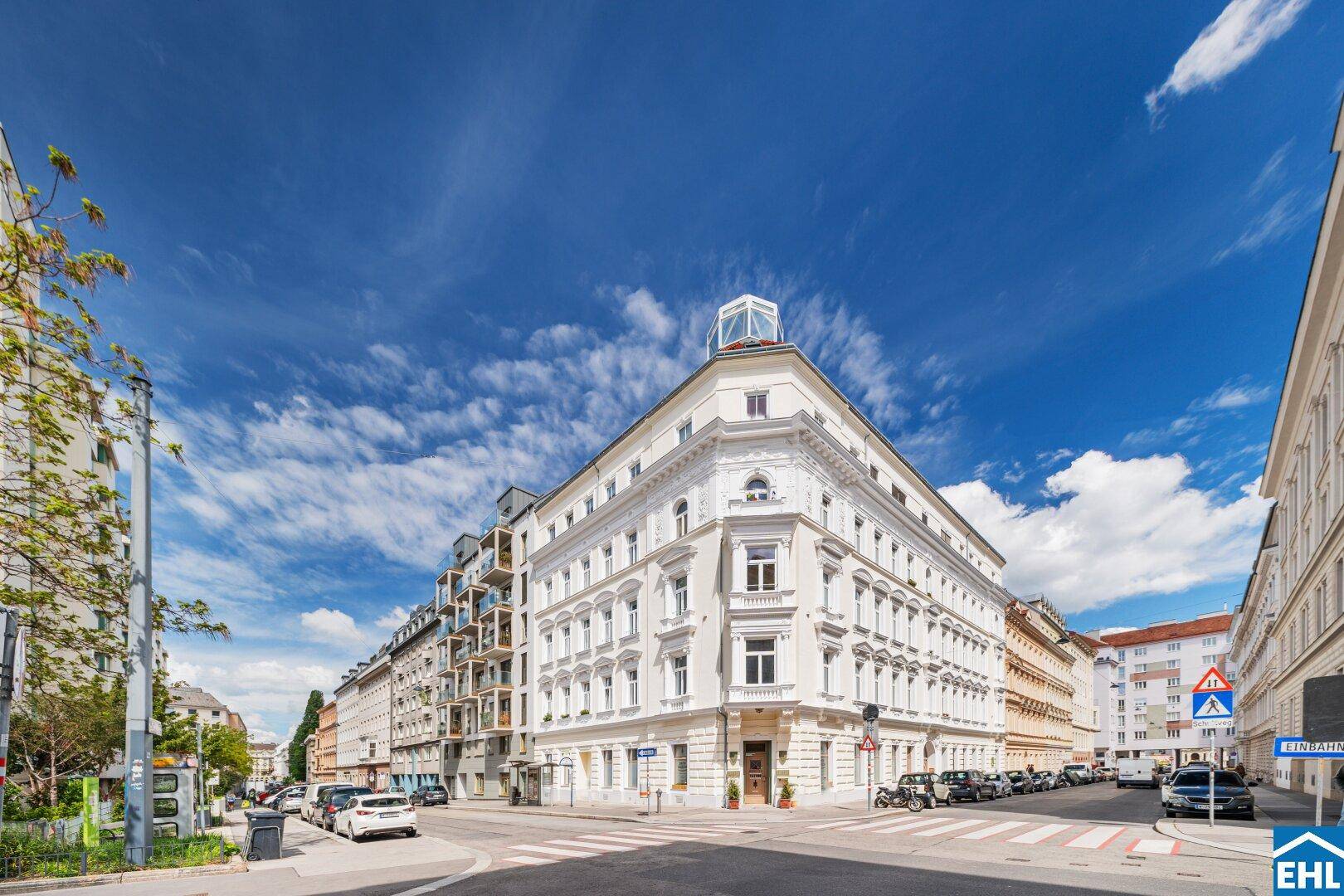 Prächtiges Eckgebäude in der Stadt mit klassischer Architektur und vielen Fenstern.