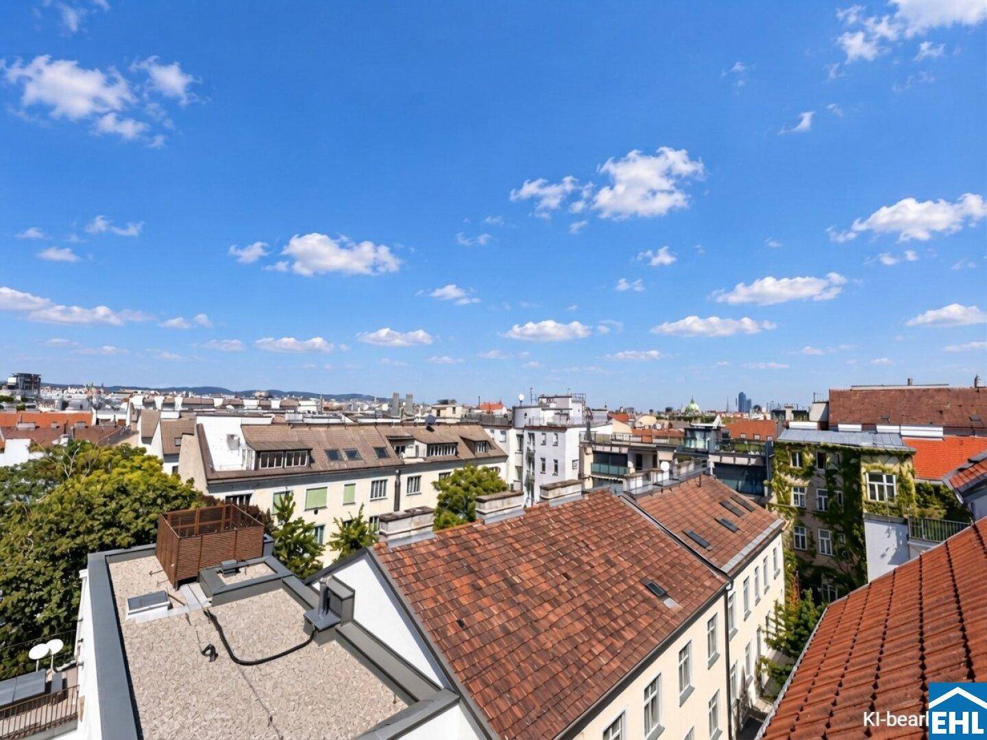 Weitläufiger Blick über die Dächer der Stadt unter einem klaren blauen Himmel.