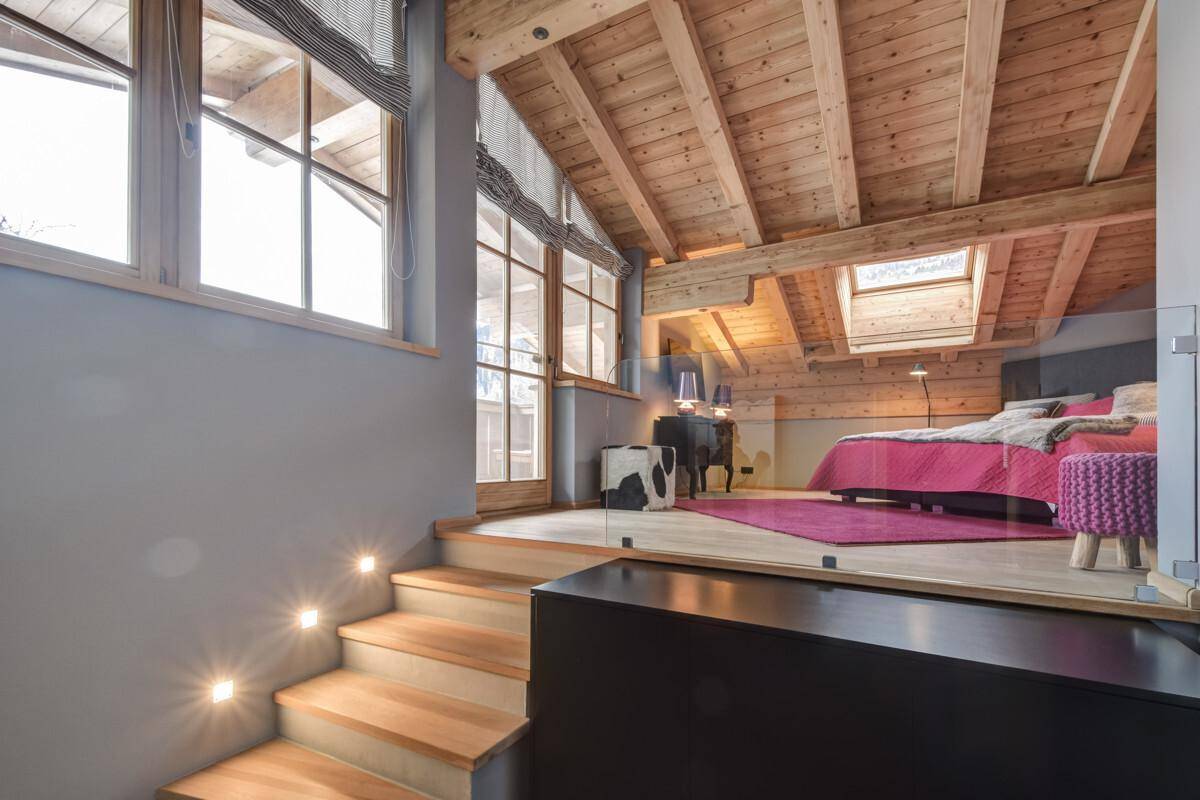 Helles Schlafzimmer im Loft-Stil mit Holzbalkendecke, Dachfenstern und moderner Einrichtung.