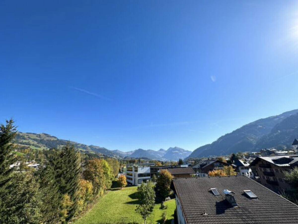 Panoramablick auf die umliegende Berglandschaft und die Stadt unter strahlend blauem Himmel.