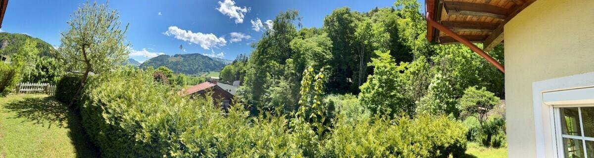 Weitläufiger Gartenbereich mit üppiger Vegetation und Blick auf die umliegende Natur.