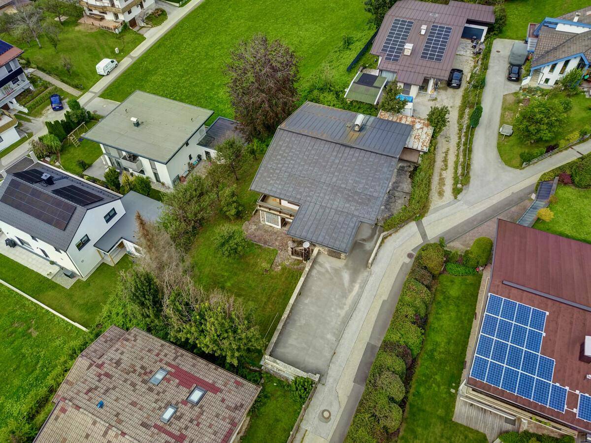 Hohe Luftaufnahme des Anwesens mit Zufahrt und umliegenden Häusern mit Solaranlagen.