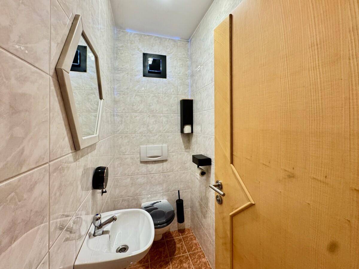 Kleines Gäste-WC mit Waschbecken, Toilette und Bidet, komplett gefliest.