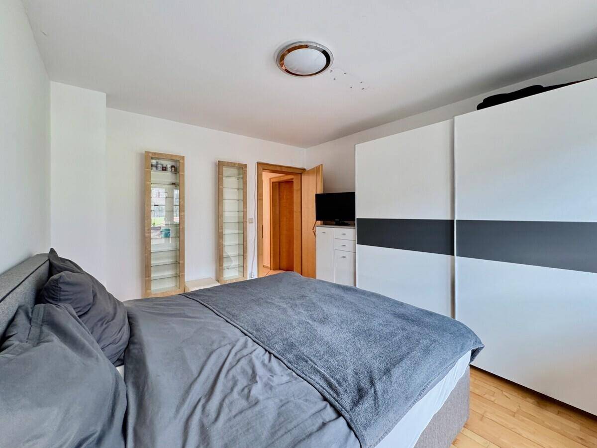 Geräumiges Schlafzimmer mit Doppelbett, großem Kleiderschrank und Holzboden.