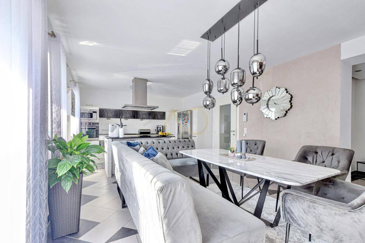 Heller Essbereich mit stilvoller Beleuchtung und Zugang zur modernen Küche.