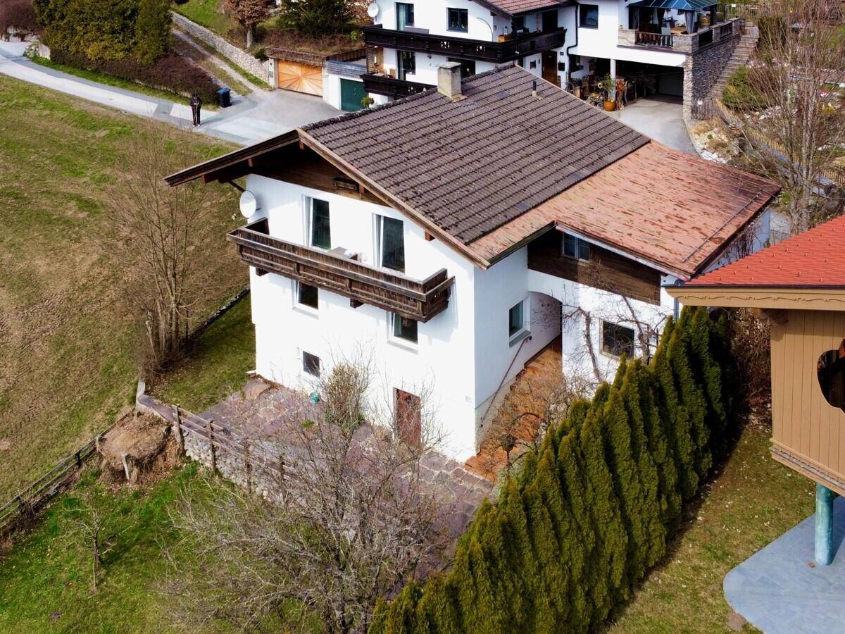 Luftaufnahme des Hauses mit Satteldach, Balkon und umliegender ländlicher Landschaft.