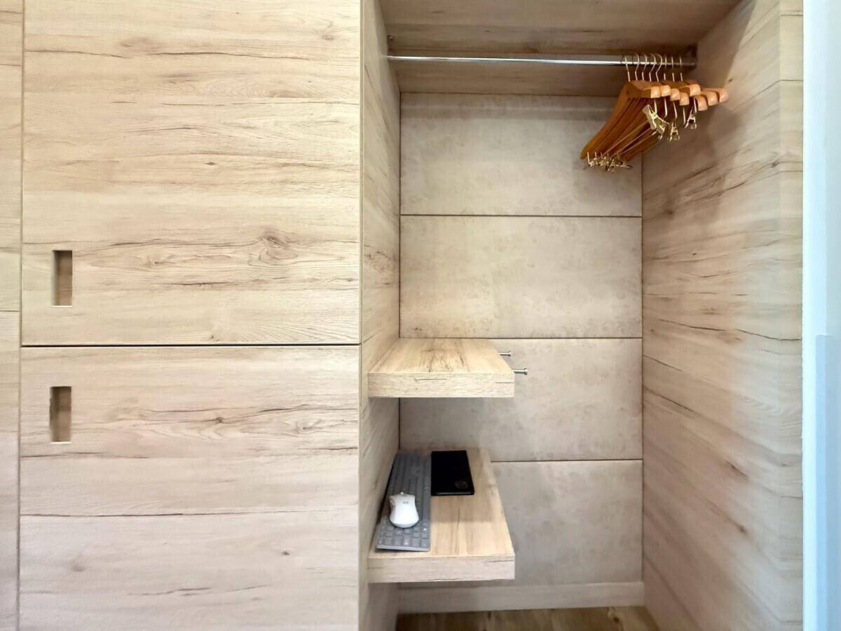 Offener Einbauschrank mit Regalen und Kleiderstange für praktische Aufbewahrung.