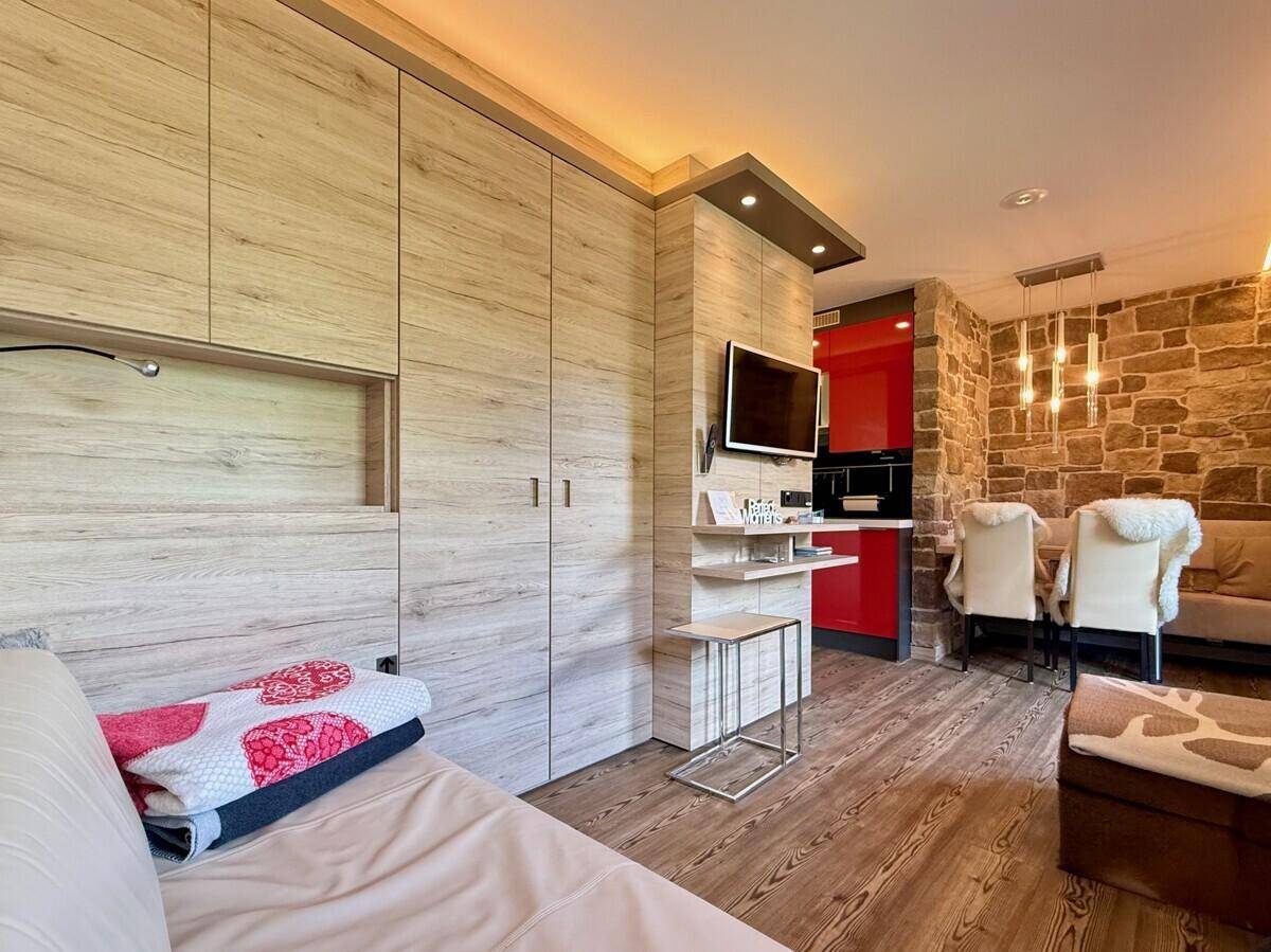 Offener Wohnbereich mit Sofa, Holzschränken und Blick auf den Ess- und Küchenbereich.