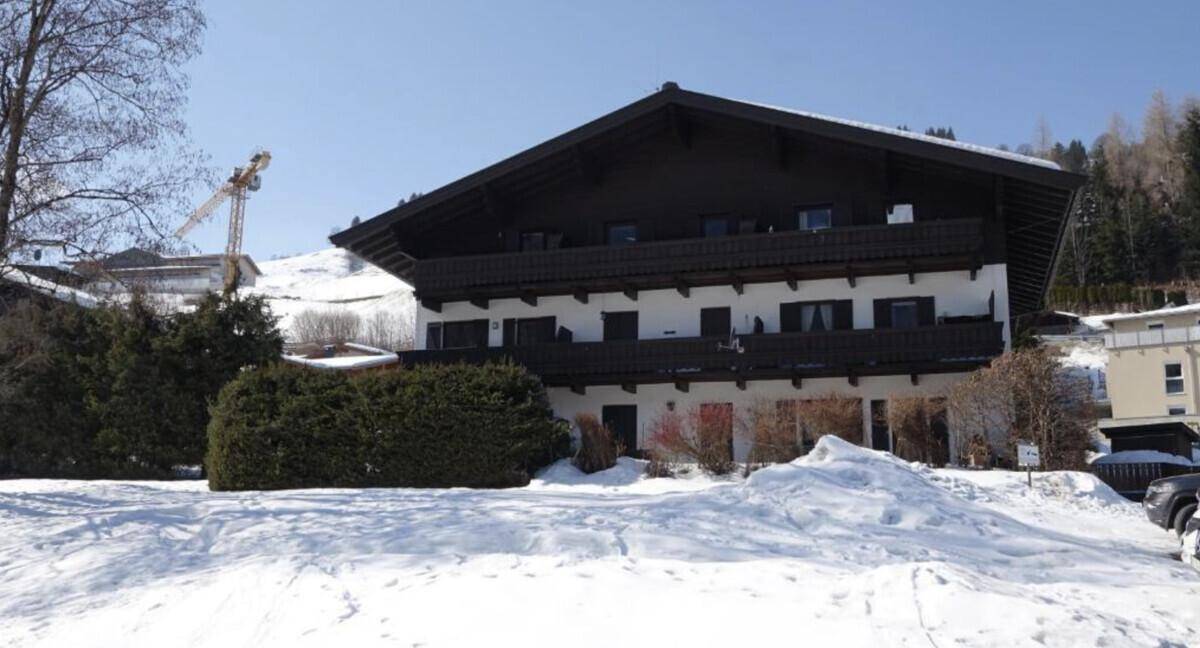 Alpines Gebäude im Winter mit schneebedeckter Landschaft und klarem Himmel.