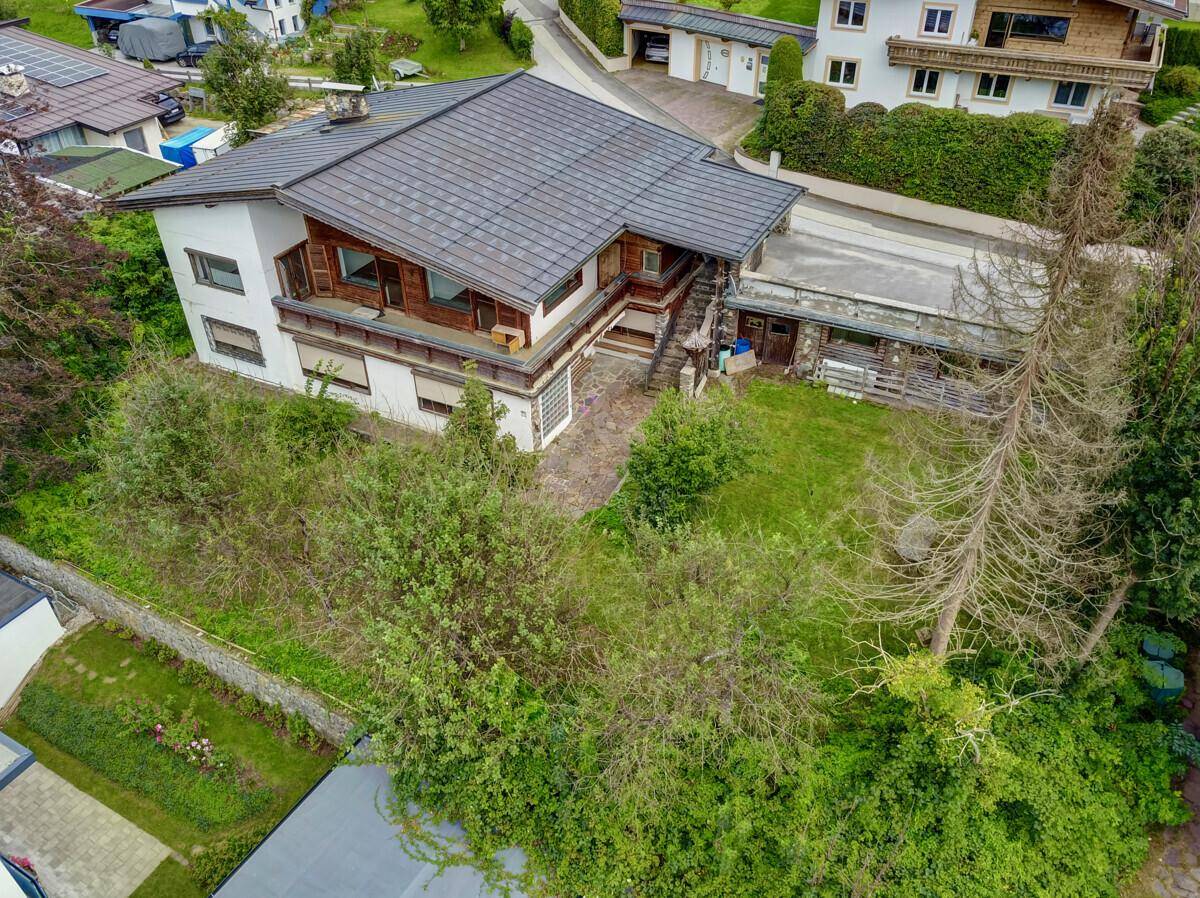 Luftaufnahme des Hauses mit großem Gartenbereich und umliegenden Bäumen.