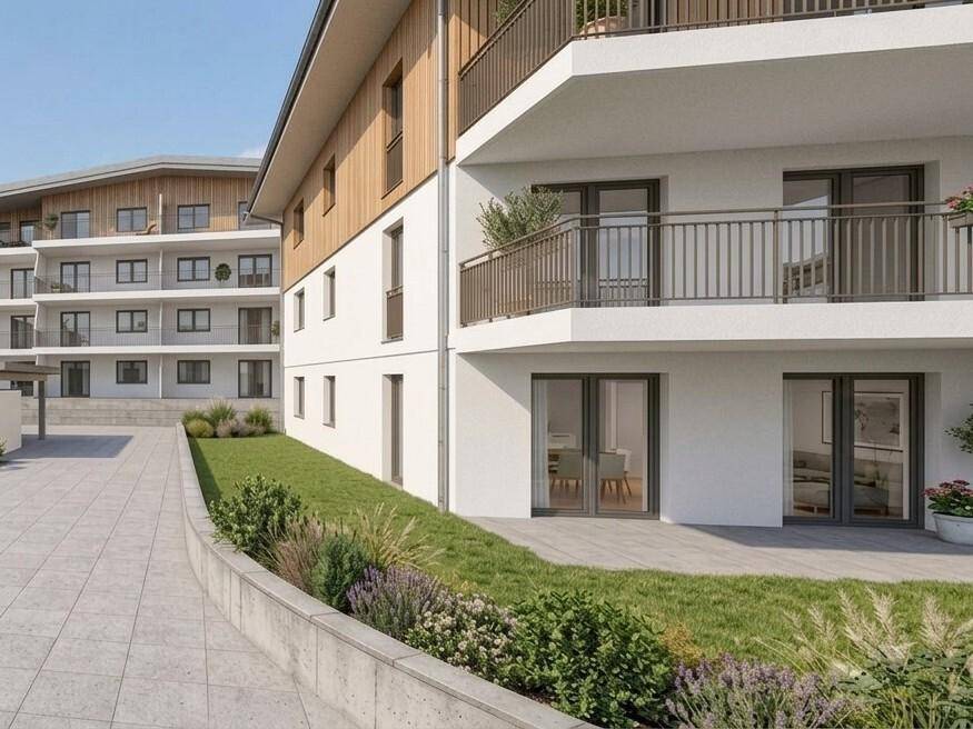 Moderne Wohnanlage mit weißer Fassade, Holzdetails und gepflegten Grünflächen.