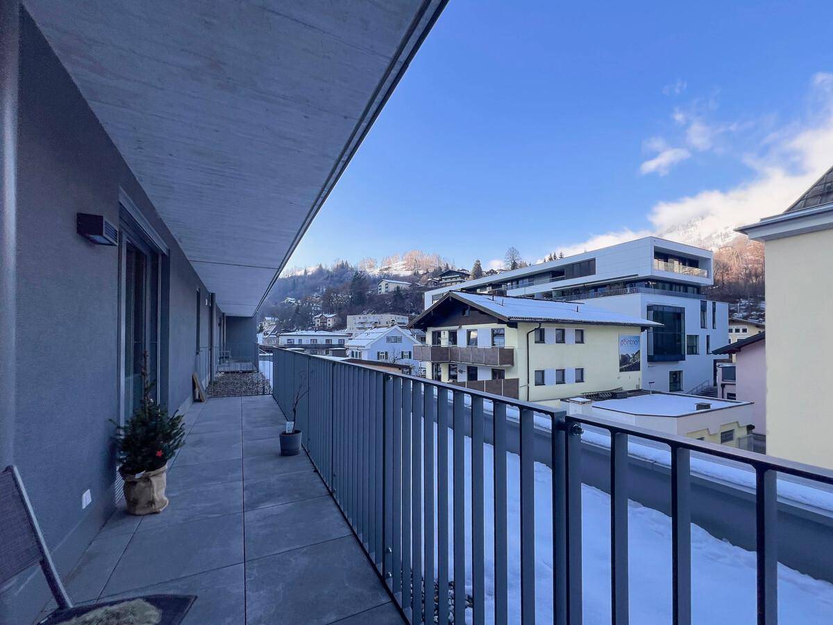 Geräumiger Balkon mit Blick auf die verschneite Landschaft und die umliegenden Häuser.