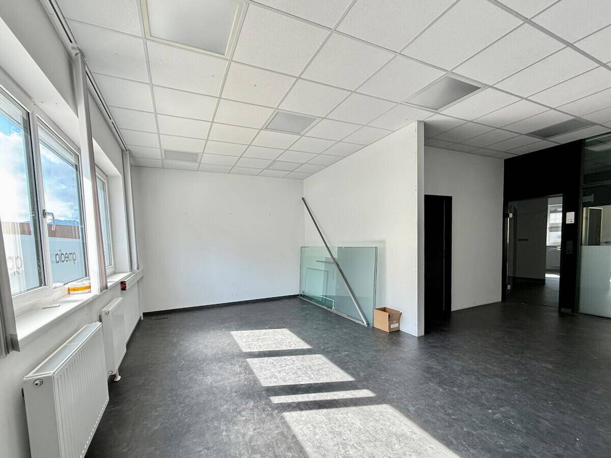 Helles Büro mit großen Fenstern und dunklem Boden, bietet viel Potenzial für individuelle Gestaltung.