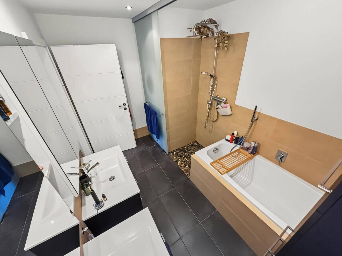 Modernes Badezimmer mit Badewanne, begehbarer Dusche und Doppelwaschbecken.
