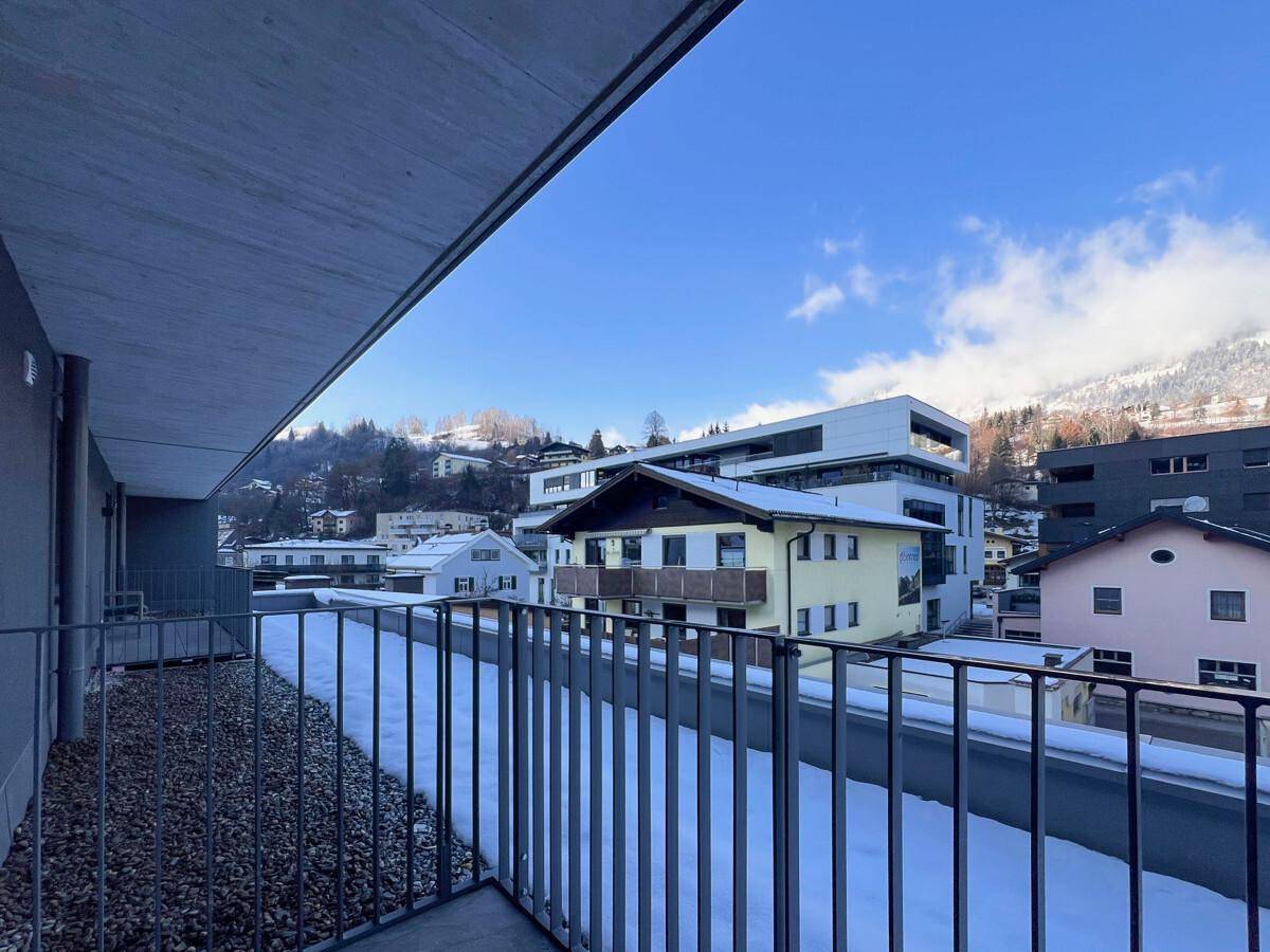 Balkon mit Blick auf die verschneite Umgebung und die umliegenden Gebäude.