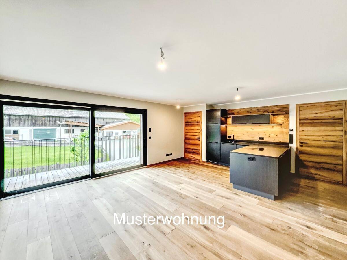Offener Wohn- und Essbereich mit moderner Küche, Holzboden und großem Schiebetürzugang zum Balkon.