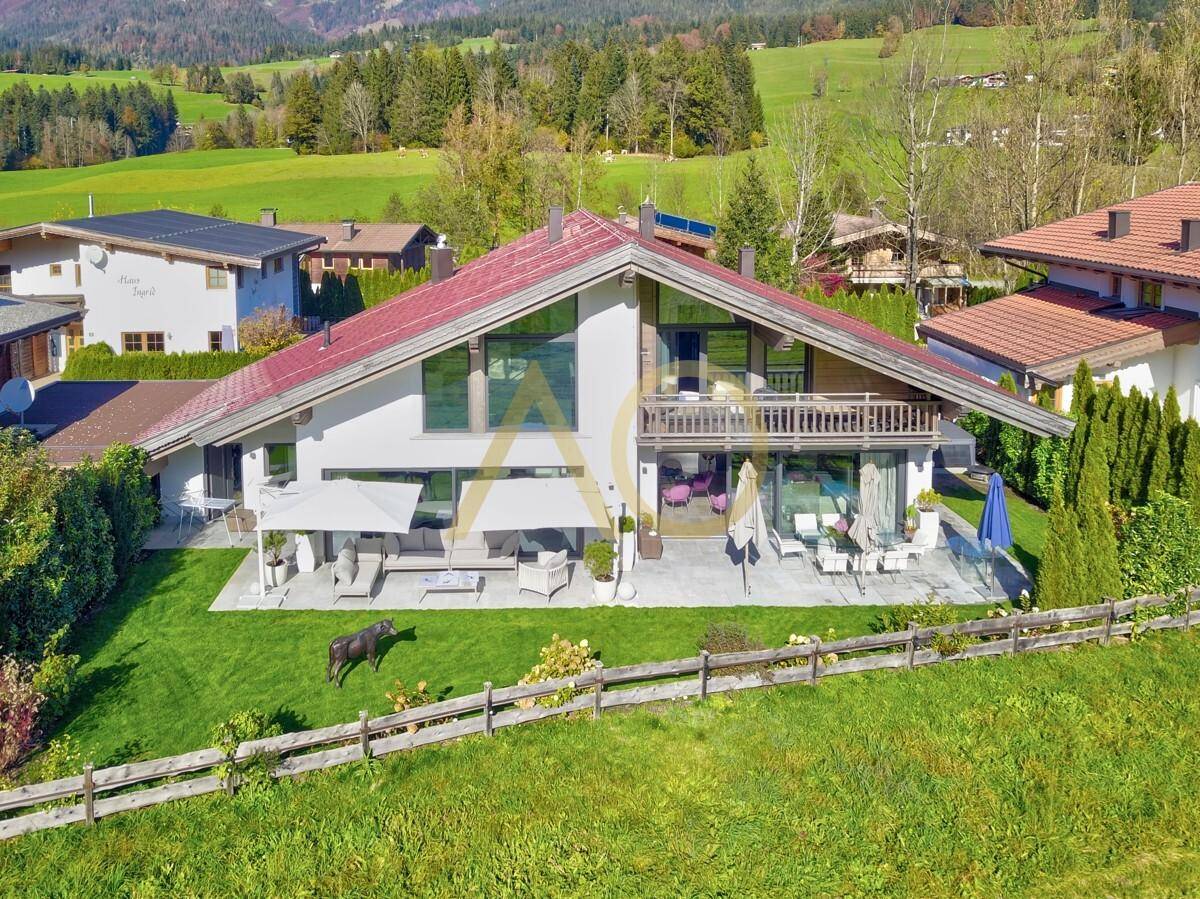 Großzügiges Einfamilienhaus mit weitläufigem Garten, sonniger Terrasse und Bergblick in idyllischer Umgebung.