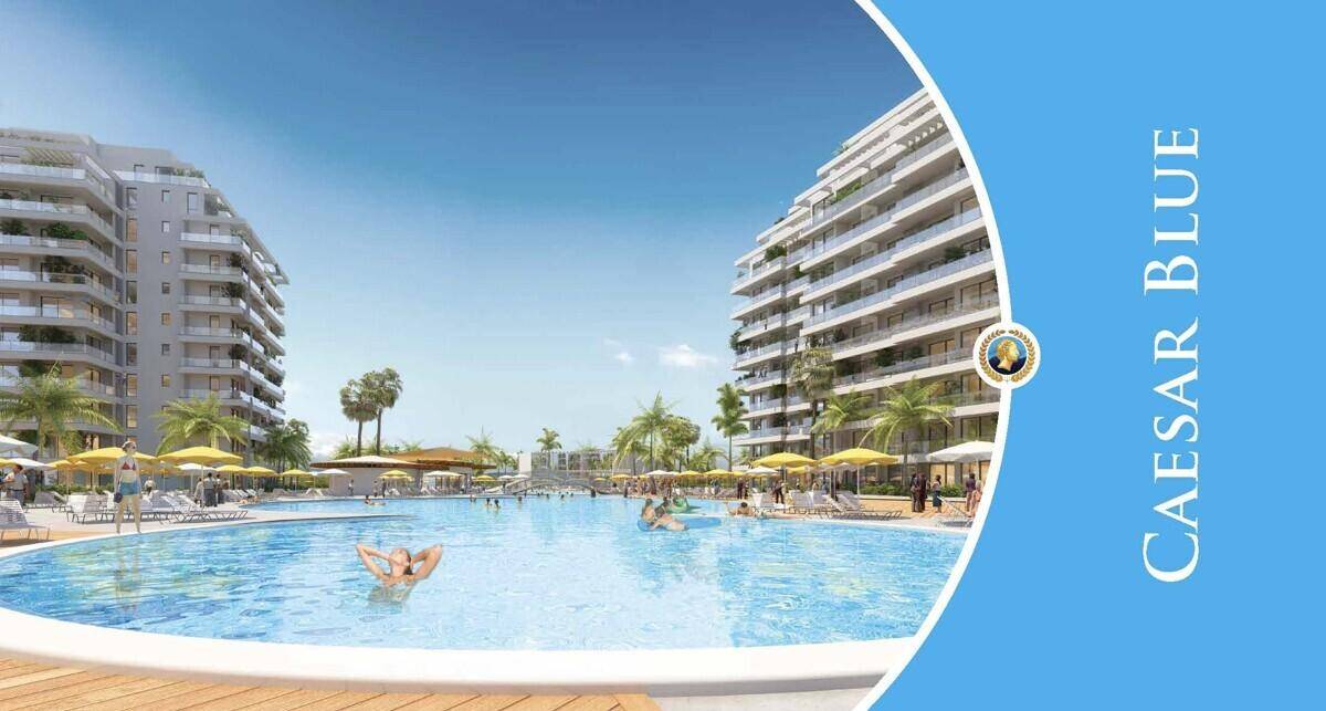 Moderne Apartmentgebäude umrahmen eine große Poollandschaft mit Sonnenliegen und schwimmenden Gästen.