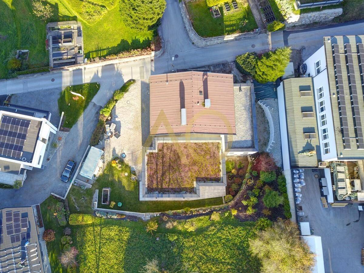 Luftaufnahme des Anwesens mit Garten, Flachdach und umliegender Bebauung.
