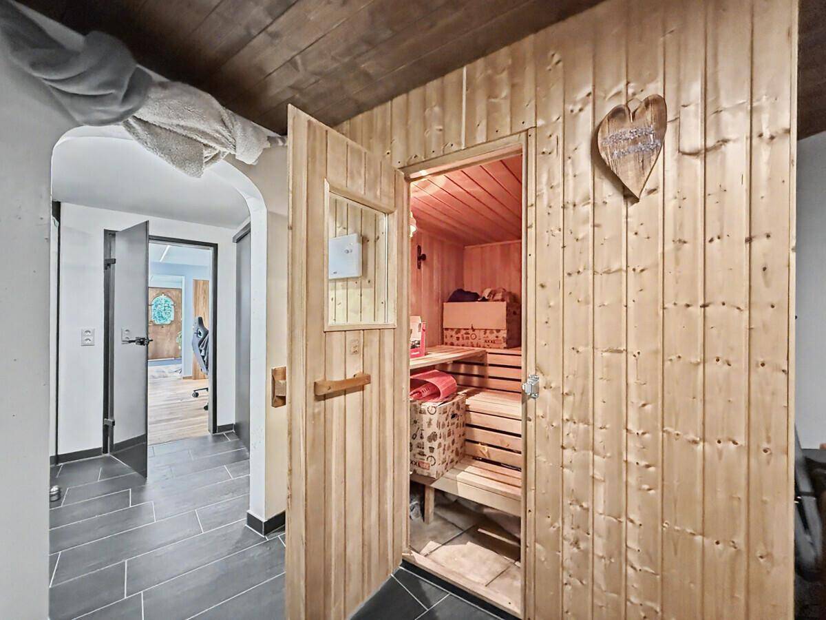Offene Saunakabine mit Holzbänken, bereit für entspannende Wellness-Momente.