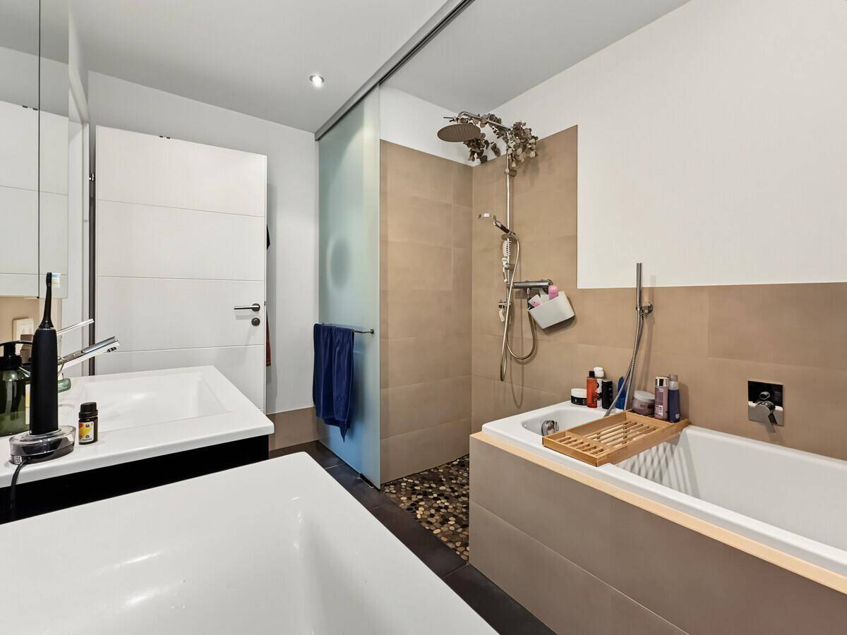 Modernes Badezimmer mit Badewanne, begehbarer Dusche und Doppelwaschbecken.