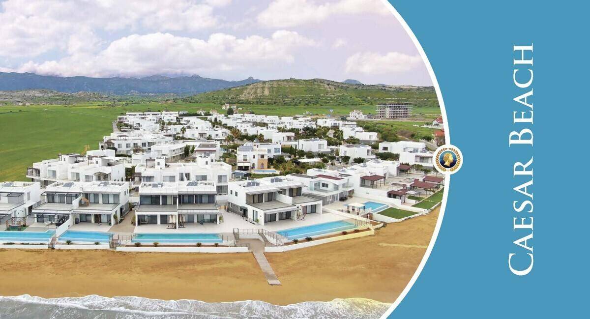 Luftaufnahme des Caesar Beach Resorts mit modernen weißen Villen und Pools direkt am Sandstrand.
