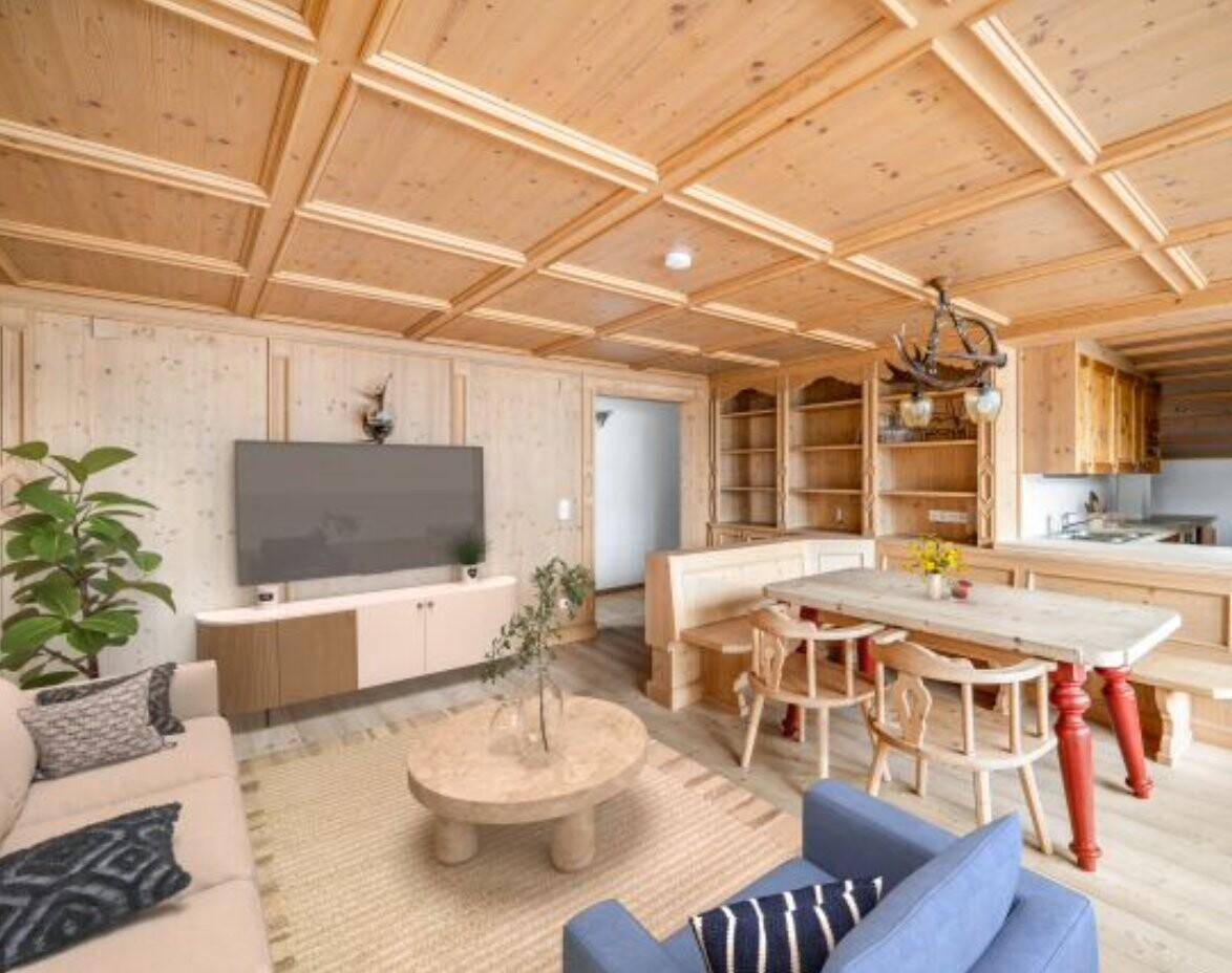 Heller Wohn-Essbereich mit Holztäfelung, modernem TV-Möbel und traditionellem Esstisch im alpinen Stil.