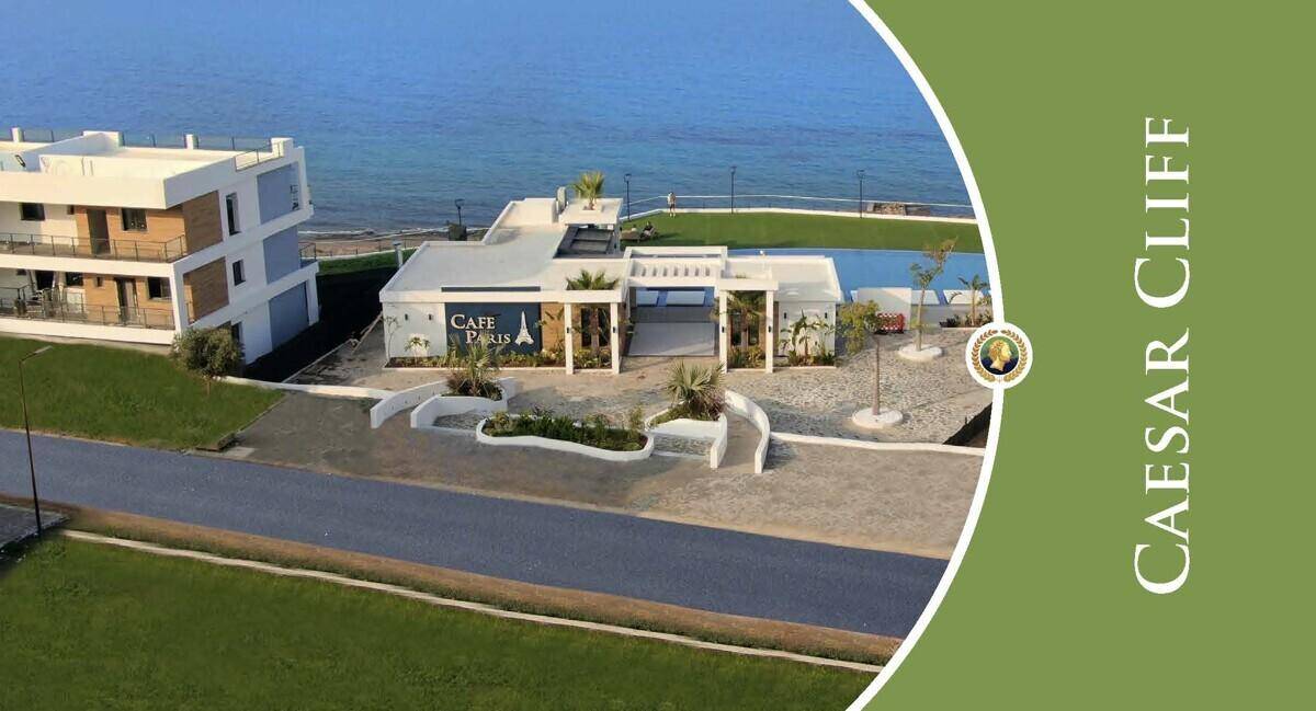 Modernes Gebäude mit Café Paris, einem Pool und dem Mittelmeer im Hintergrund, Teil des Caesar Cliff Resorts.