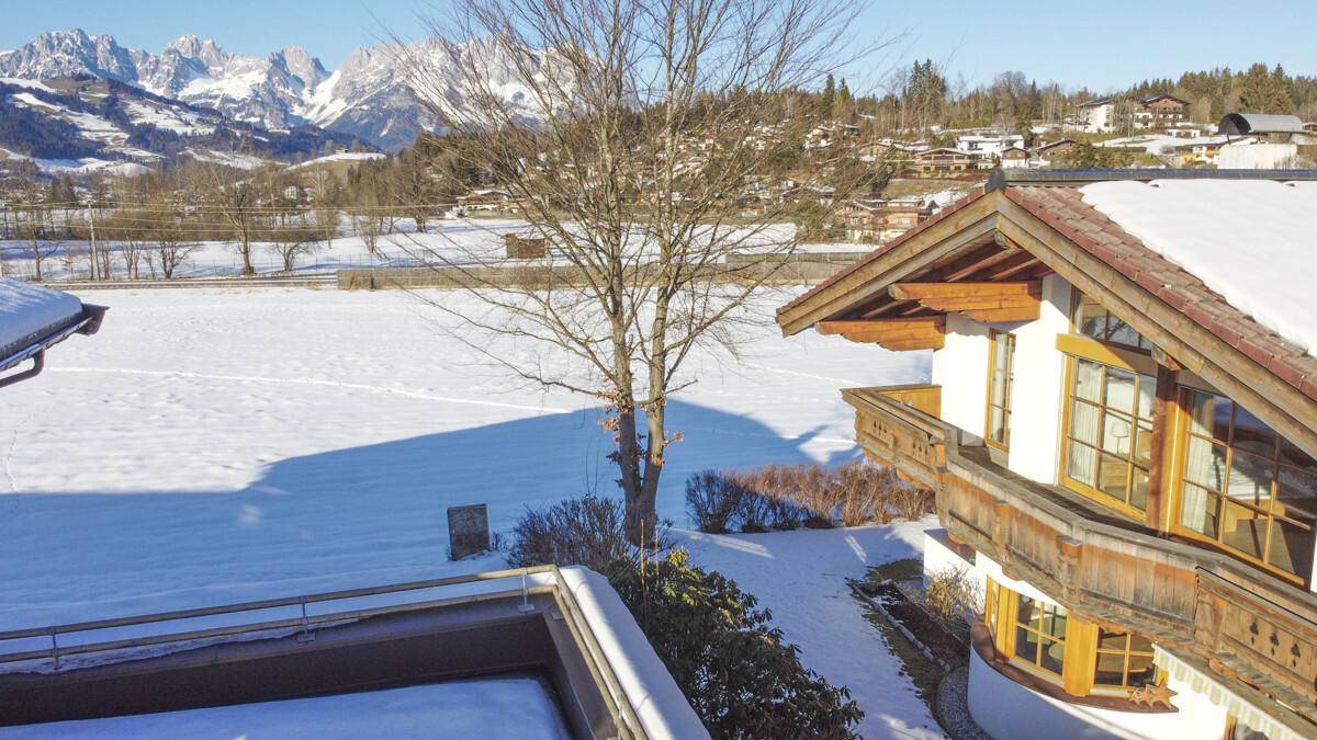 Balkon mit Blick auf die verschneite Landschaft und die majestätischen Berge im Hintergrund.