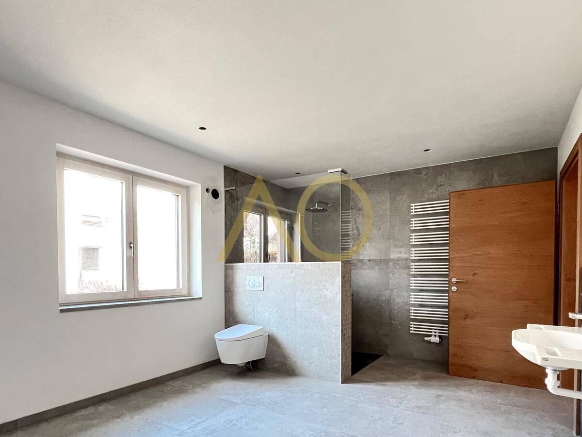 Modernes Badezimmer mit begehbarer Dusche, Wand-WC und Fenster für Tageslicht.