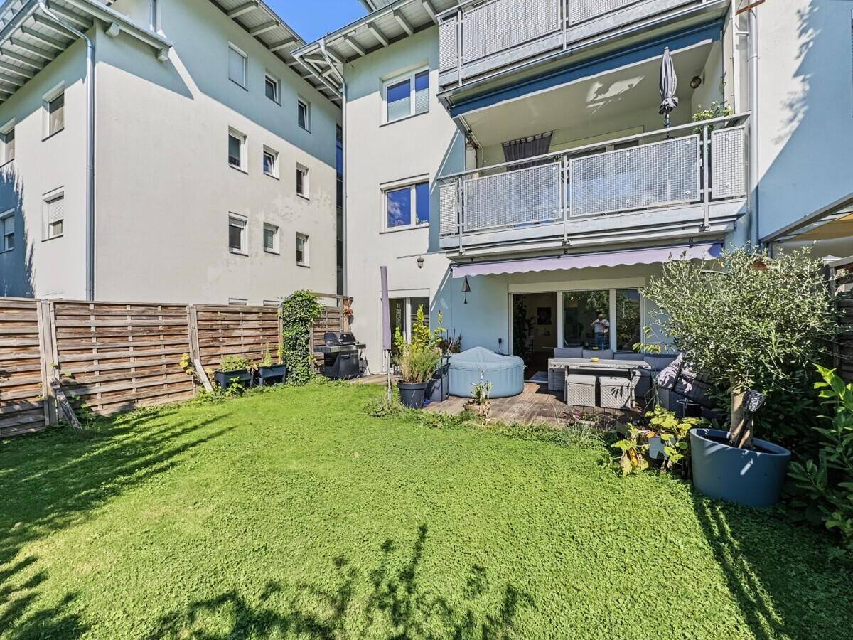 Gepflegter Gartenbereich mit Rasenfläche, Terrasse und Blick auf das Wohngebäude.