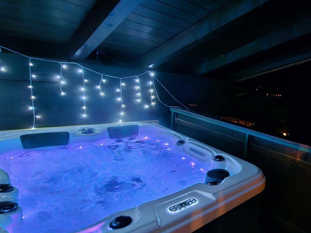 Beleuchteter Whirlpool im Freien bei Nacht, perfekt für entspannende Abende.