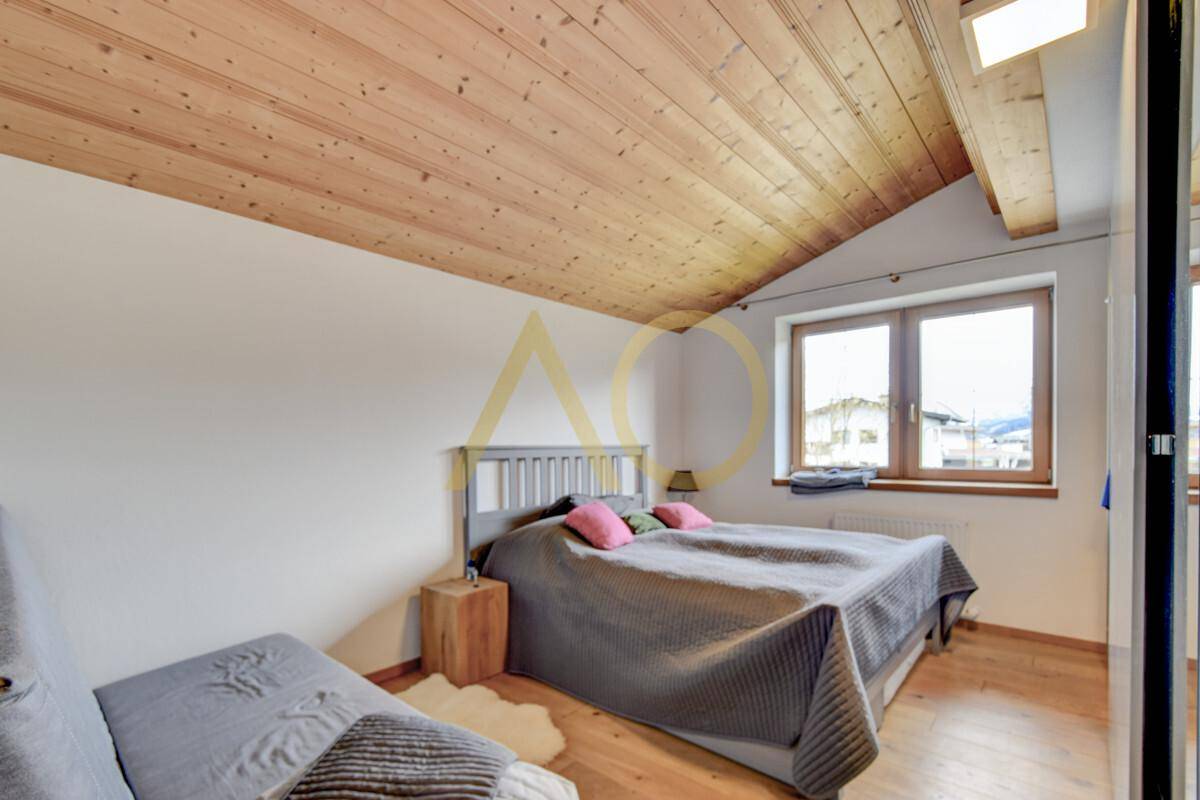 Gemütliches Schlafzimmer im Dachgeschoss mit Holzdachschräge und natürlichem Lichteinfall.