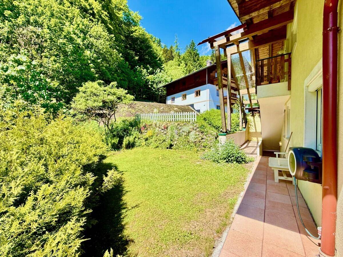 Gepflegter Gartenbereich mit Rasenfläche und Blick auf die umliegende Natur.