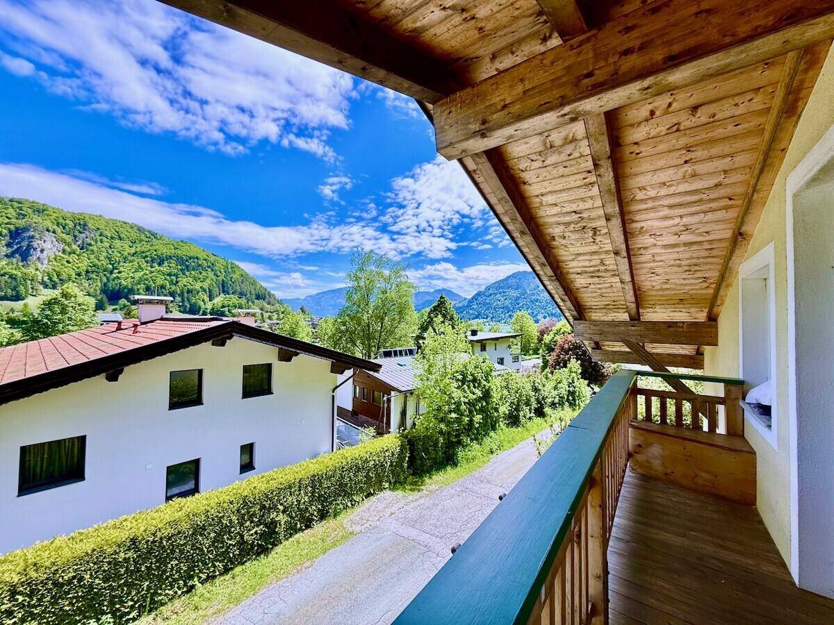 Balkon mit Holzboden und Geländer, bietet einen weiten Blick auf die umliegende Berglandschaft.
