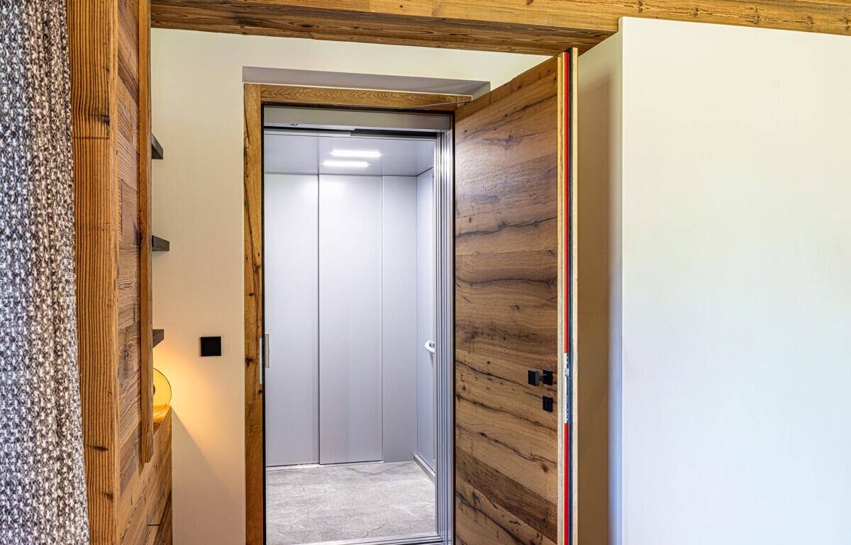 Moderner Aufzug mit Holztür, der die verschiedenen Etagen des Gebäudes verbindet.
