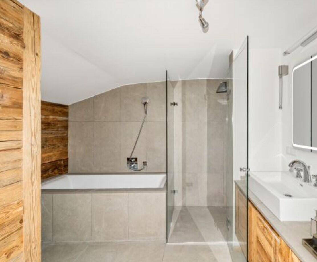 Modernes Badezimmer mit Badewanne, begehbarer Dusche und Waschtisch mit Holzunterschrank.