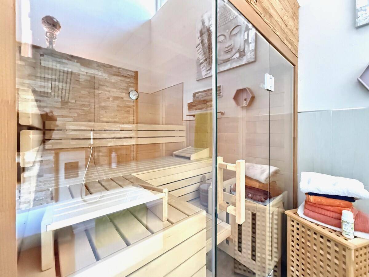 Moderne Sauna mit Holzbänken und Glasfront, ideal zur Entspannung.