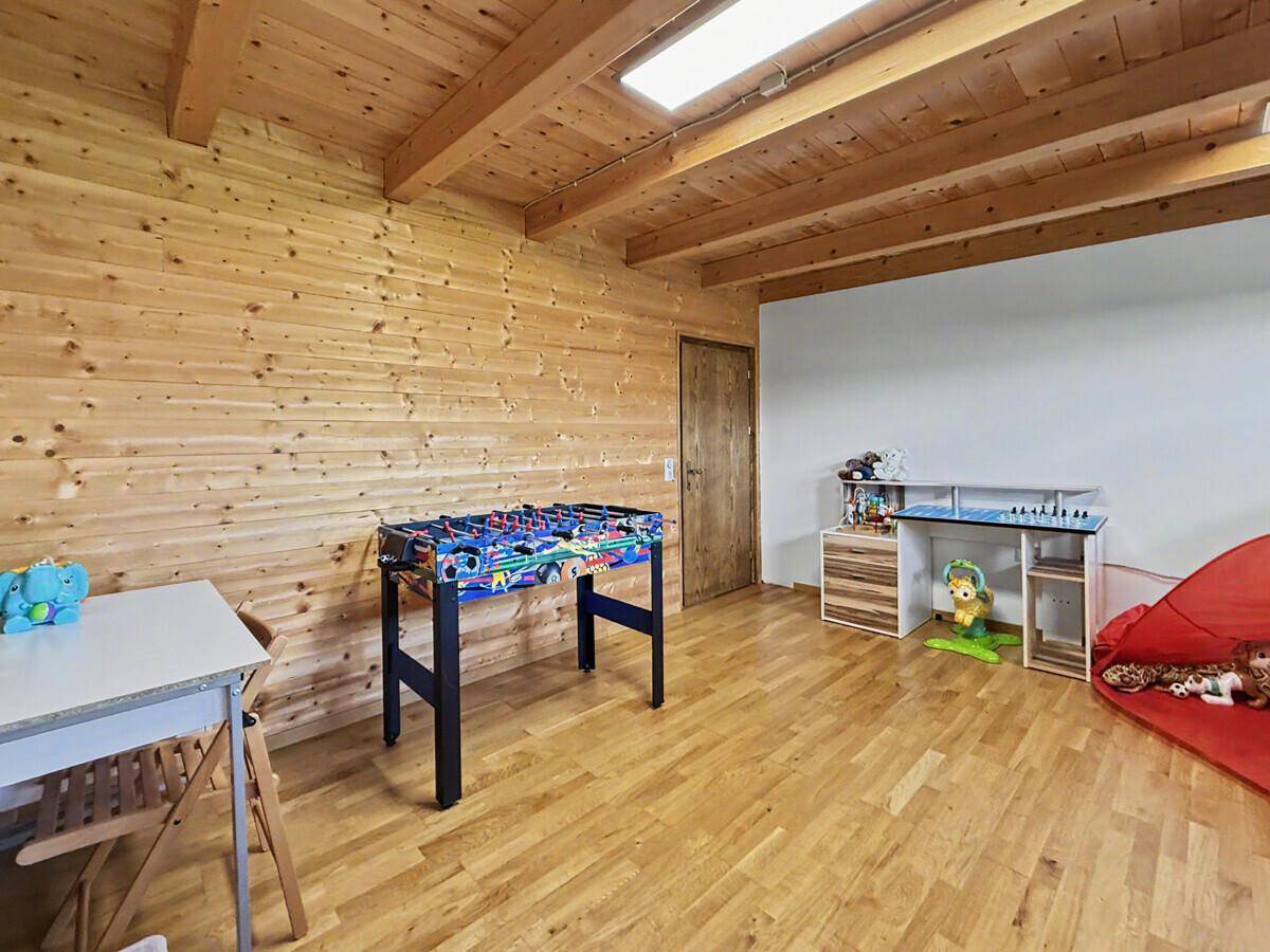 Spielzimmer mit Tischfußball und Holztür, bietet viel Platz für Aktivitäten.