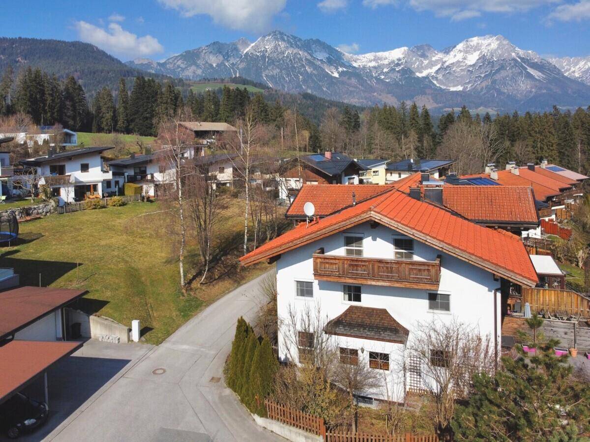 Haus mit rotem Ziegeldach in einer malerischen Wohngegend mit beeindruckendem Bergblick.